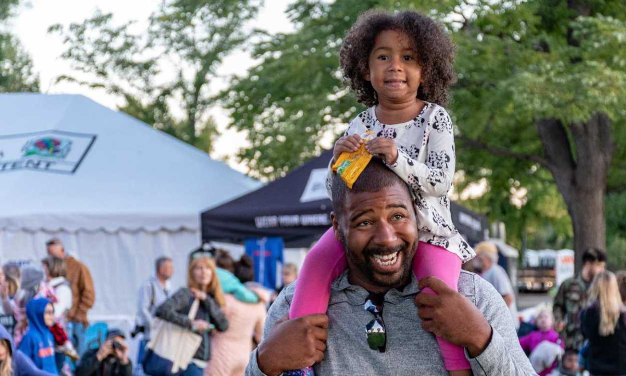 A picture of a man and his daughter enjoying a festival. Photo by Brett Sayles from Pexels.